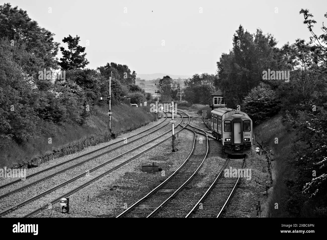 Treno DMU classe 150 Northern Rail 150214 che passa i segnali a semaforo all'incrocio Settle e si dirige verso la piccola linea nord-occidentale Foto Stock