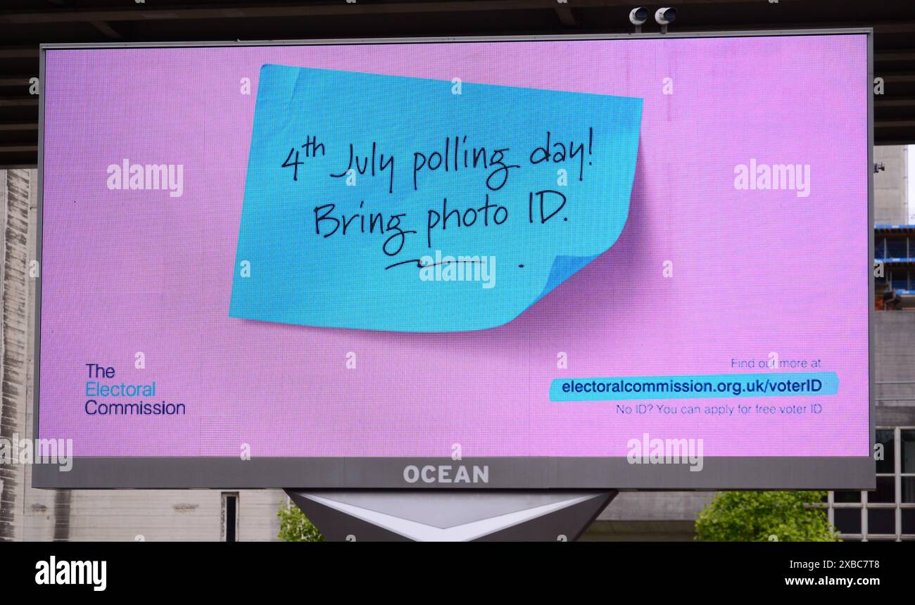La commissione elettorale utilizza un cartellone elettronico a Manchester, nel Regno Unito, per dire alla gente che gli elettori in Inghilterra dovranno mostrare un documento d'identità per votare il 4 luglio Foto Stock