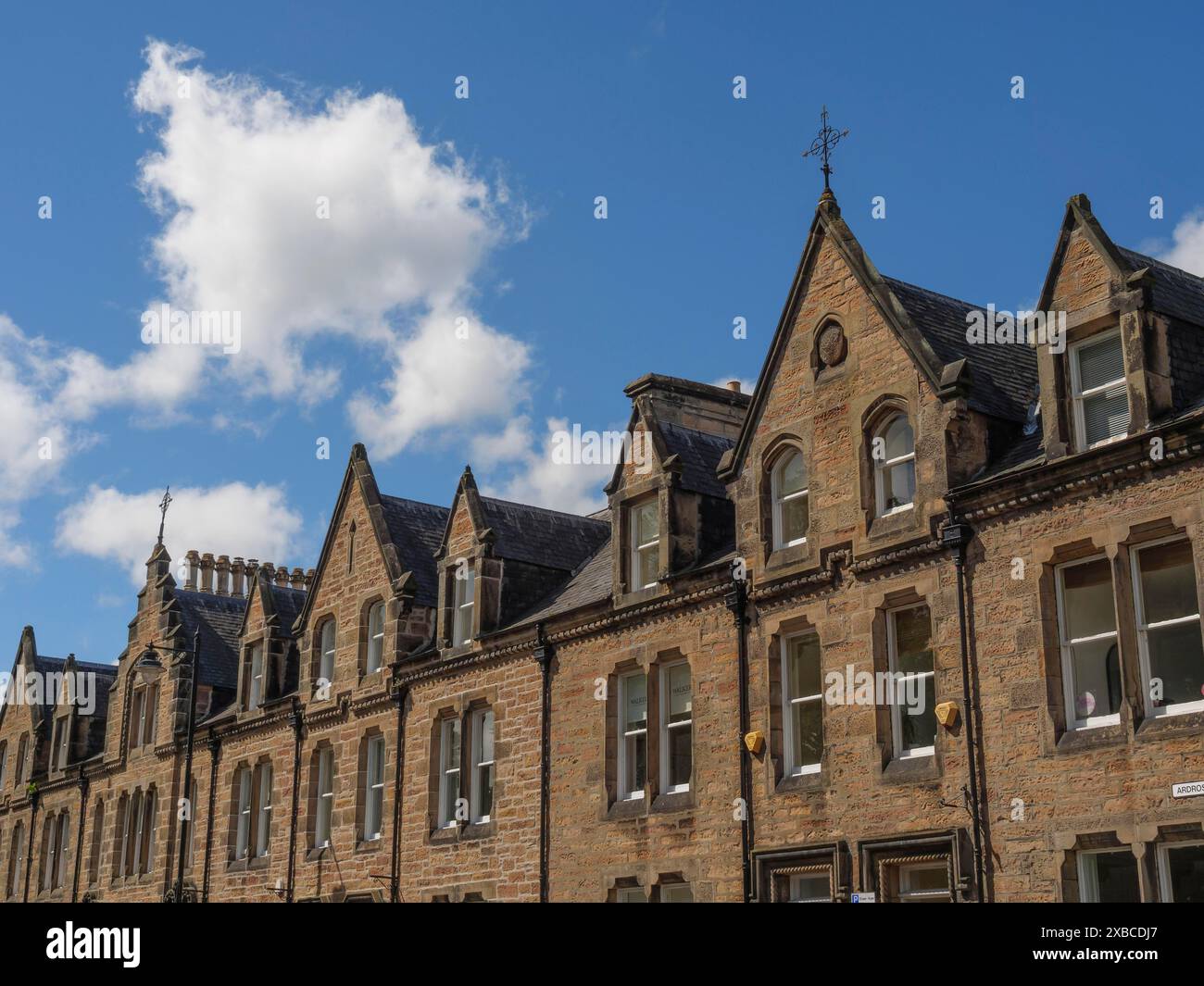 Fila di edifici storici con frontoni a punta e facciate in pietra sotto un cielo blu in un paesaggio urbano, inverness, scozia, Gran Bretagna Foto Stock