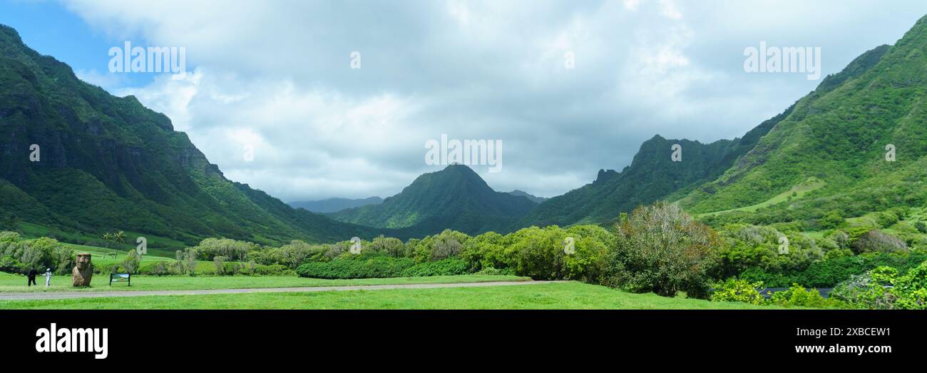 Vista panoramica di lussureggianti montagne verdi e una valle con un cielo nuvoloso al Kualoa Ranch, Oahu, Hawaii Foto Stock
