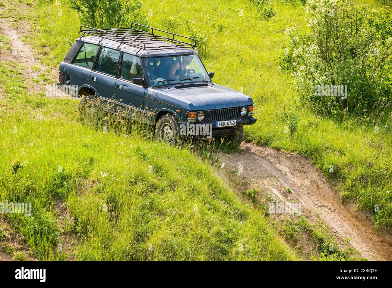 Veltrusy, repubblica Ceca - 20 giugno 2021. Vecchia auto fuoristrada blu Range Rover Classic che guida in polvere in collina Foto Stock