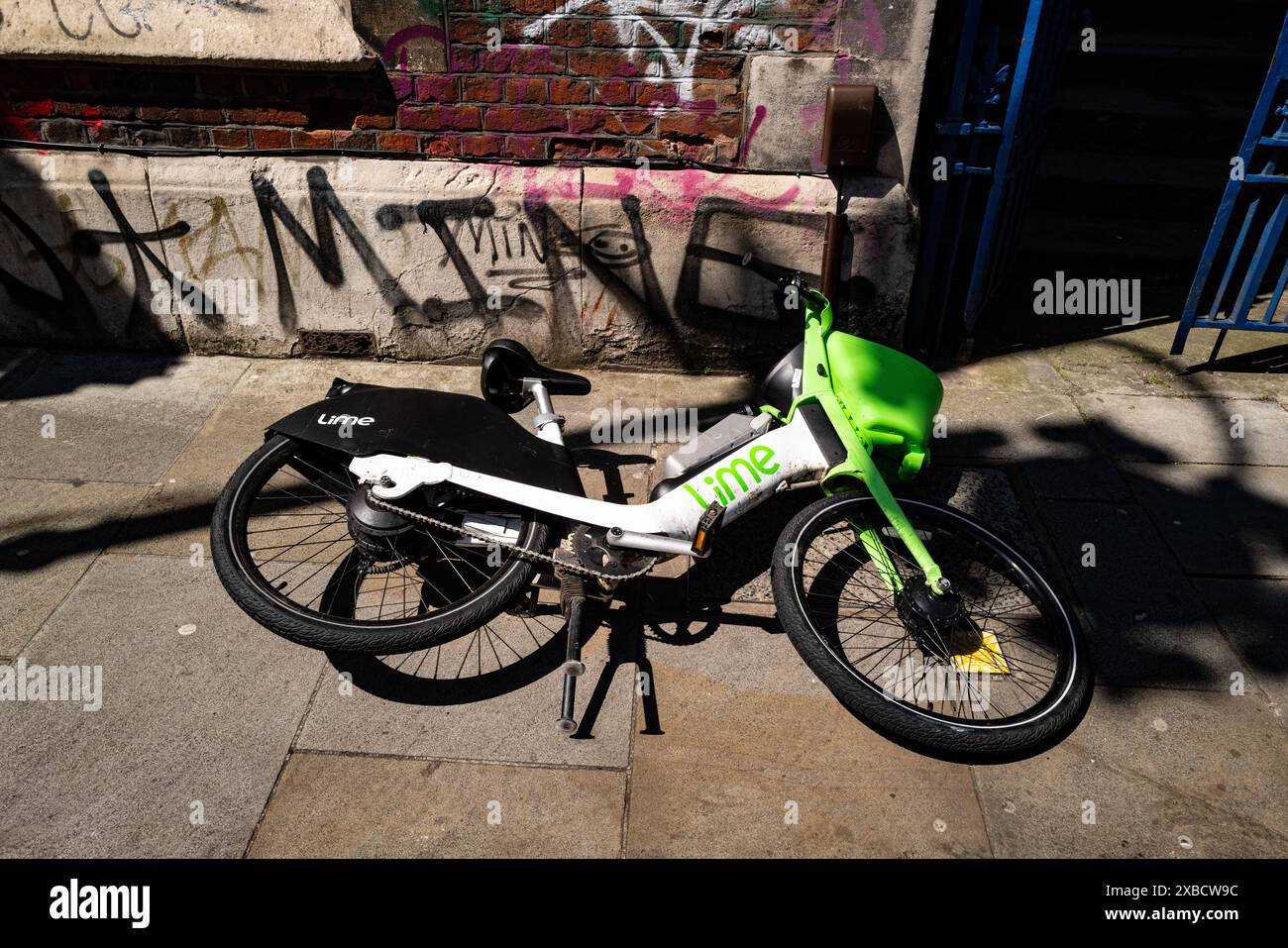 Lime è il più grande fornitore di veicoli elettrici condivisi al mondo. Questa immagine è di una bici elettrica a marchio Lime scartata in una London Street, Regno Unito Foto Stock