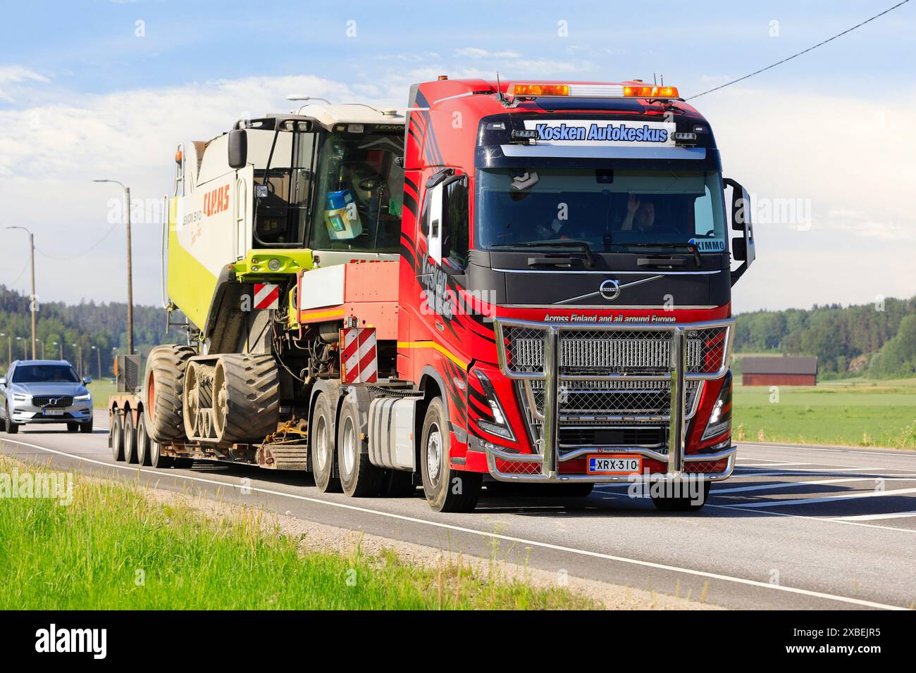 Il rimorchio con caricatore basso Volvo FH16 Kosken Autokeskus trasporta la mietitrebbia Claas Lexion 560 come carico eccezionale. Salo, Finlandia. 31 maggio 2024. Foto Stock