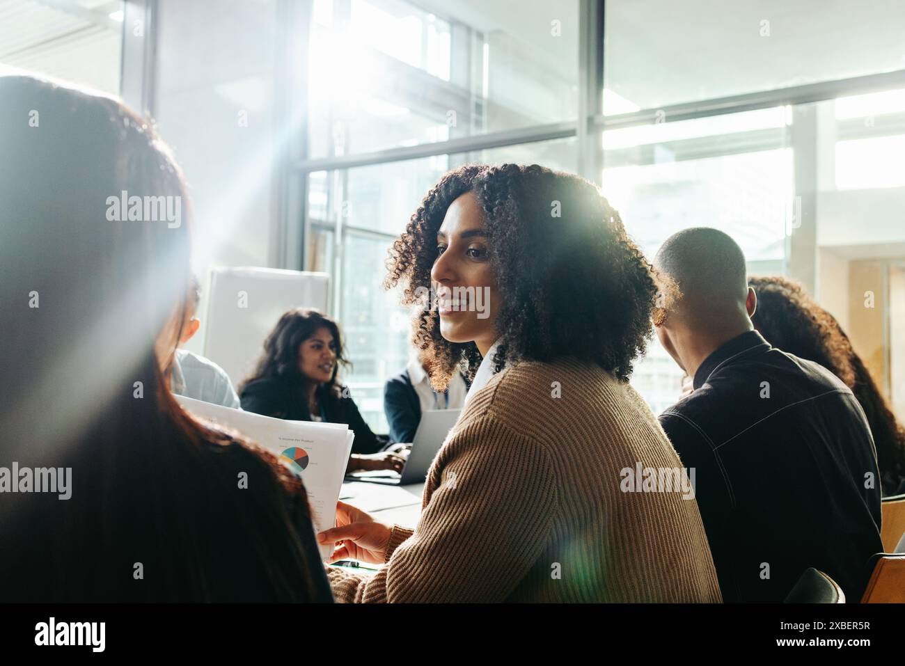 Donna d'affari che collabora con diversi gruppi di colleghi, partecipa a una riunione aziendale produttiva in un ufficio contemporaneo. Foto Stock
