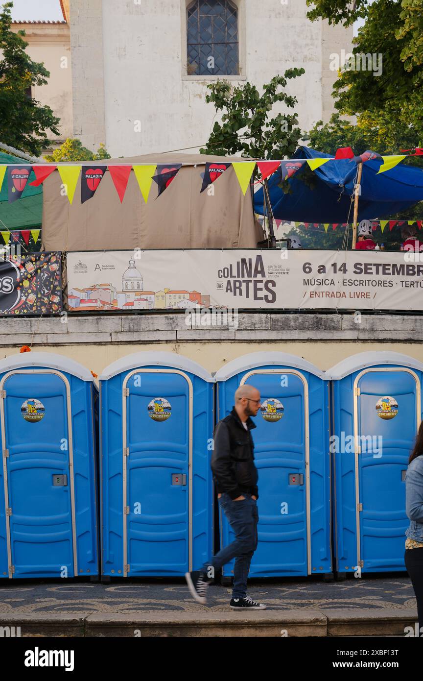 Visitatore a jardim da grazia durante le famose feste dei santi, camminando vicino ai bagni portatili e alle decorazioni colorate Foto Stock
