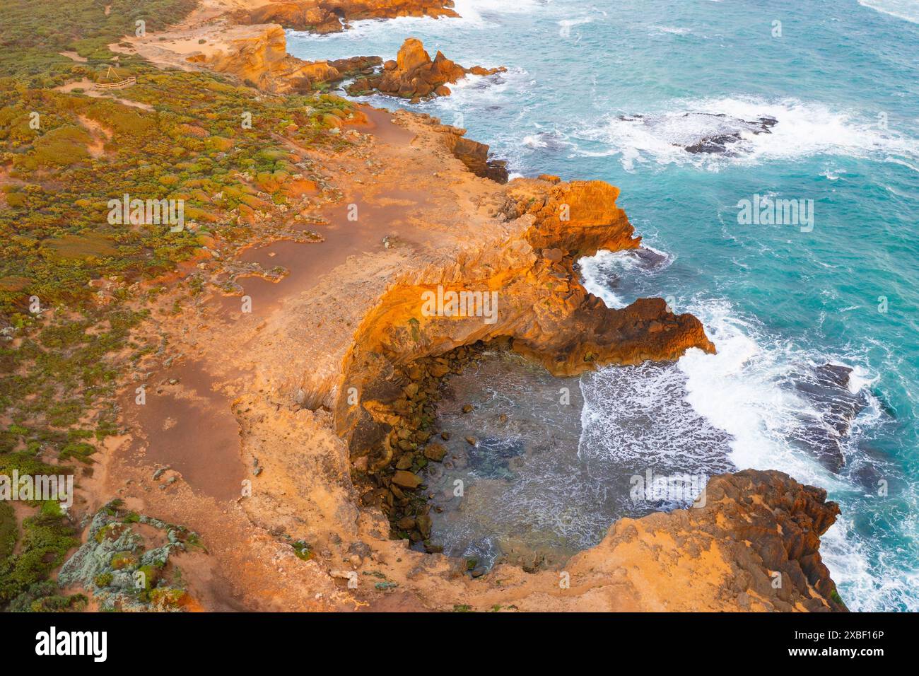 Vista aerea delle onde che si infrangono intorno a una baia riparata lungo una costa frastagliata a Warrnambool sulla Great Ocean Road a Victoria, Australia Foto Stock