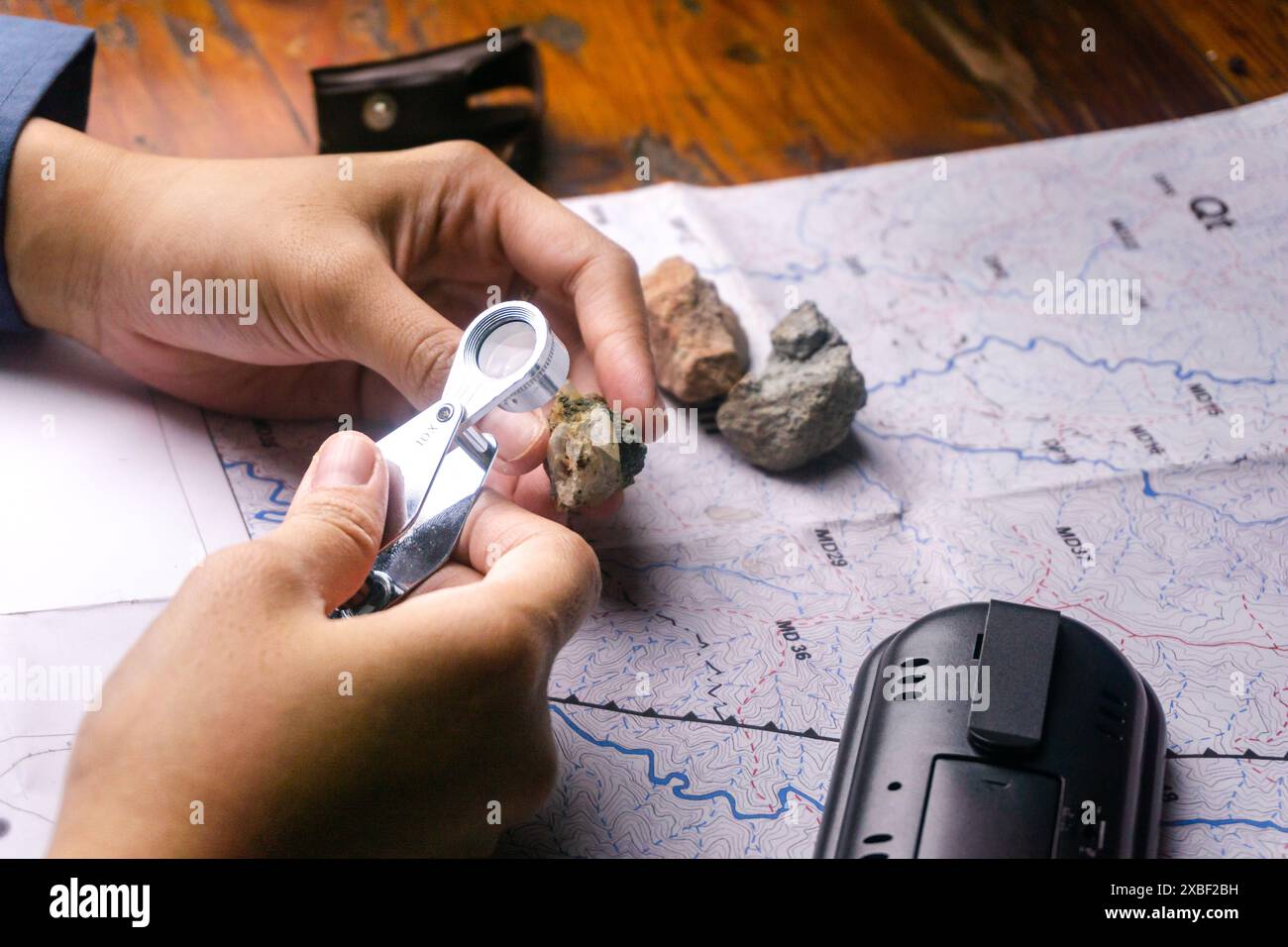 geologo che utilizza una feritoia per l'identificazione e la descrizione di rocce e minerali Foto Stock