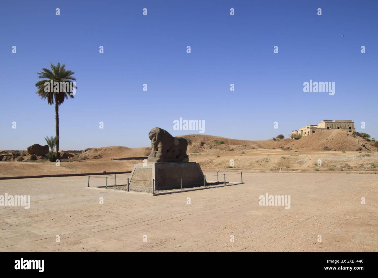 Il Leone di Babilonia, 2600 anni, in Iraq con il palazzo di Saddam su una collina in Iraq Foto Stock