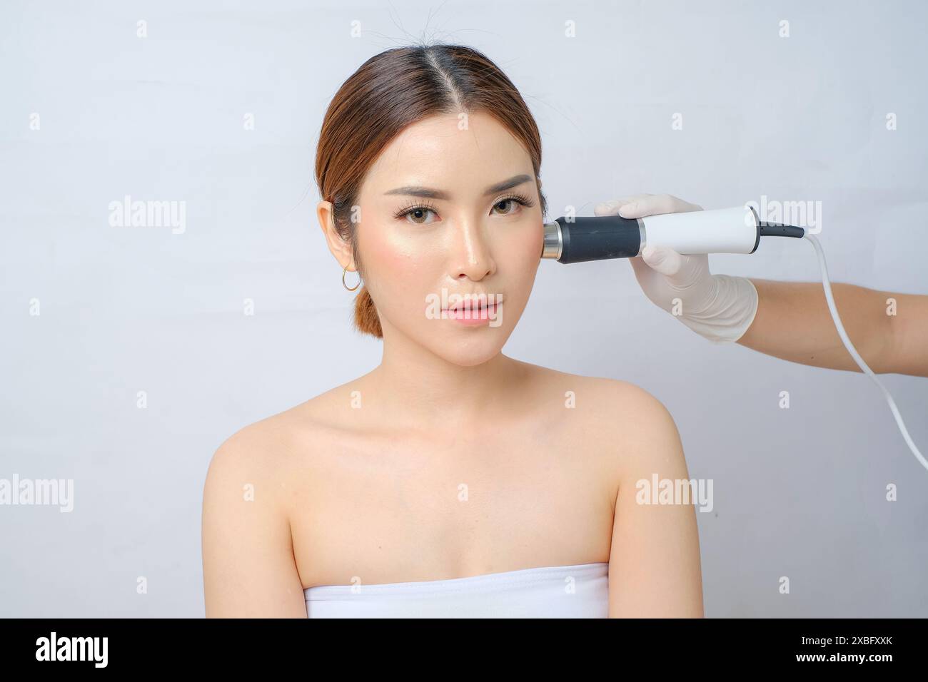 Elegante donna asiatica che ha radioterapia a ultrasuoni per il ringiovanimento della pelle Foto Stock