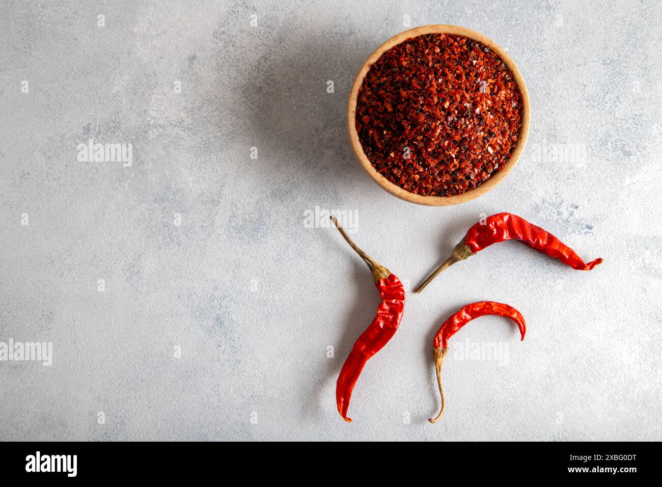Peperoncino rosso. Peperoncini rossi in un recipiente di legno su sfondo azzurro. Peperoncini secchi Foto Stock