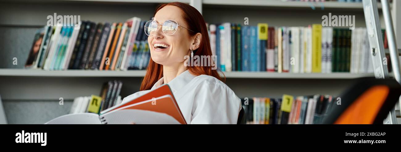 Una donna dai capelli rossi immersa in un libro in una biblioteca, immersa nell'apprendimento e nell'esplorazione. Foto Stock