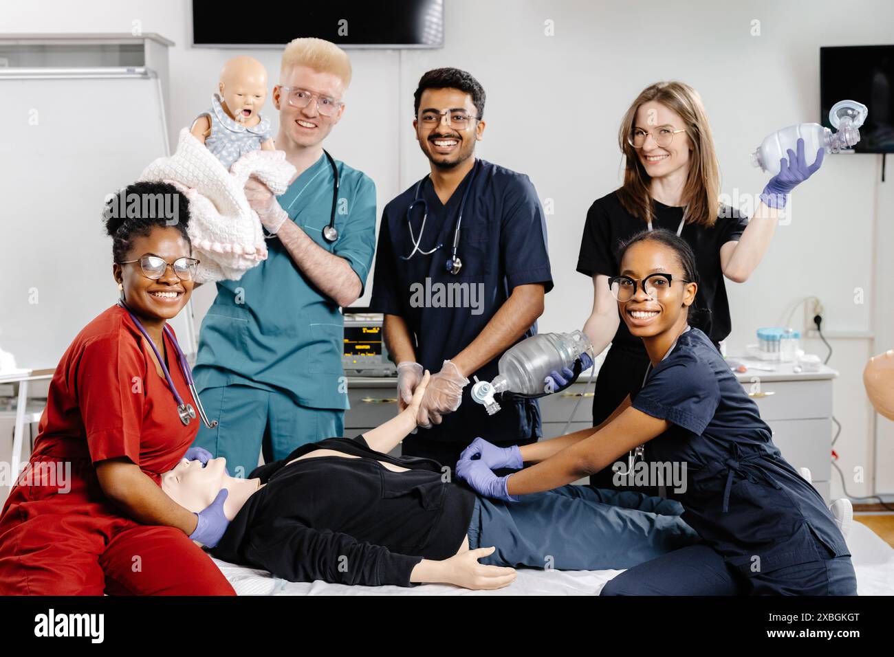 Un gruppo di studenti di medicina pratica la rianimazione cardiopolmonare su un manichino durante una sessione di formazione. Foto Stock