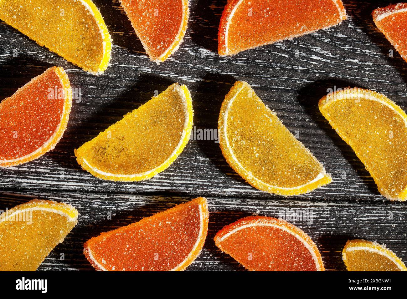 vista dall'alto con caramelle agli agrumi su sfondo in legno nero Foto Stock