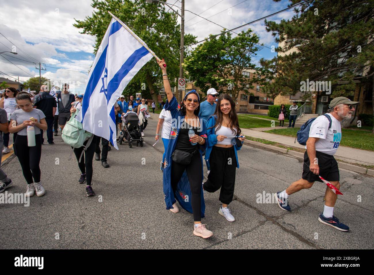 Le persone detengono la bandiera di Israele durante la marcia annuale dell'UJA (United Jewish Appeal Federation of Greater Toronto) per Israele. Foto Stock
