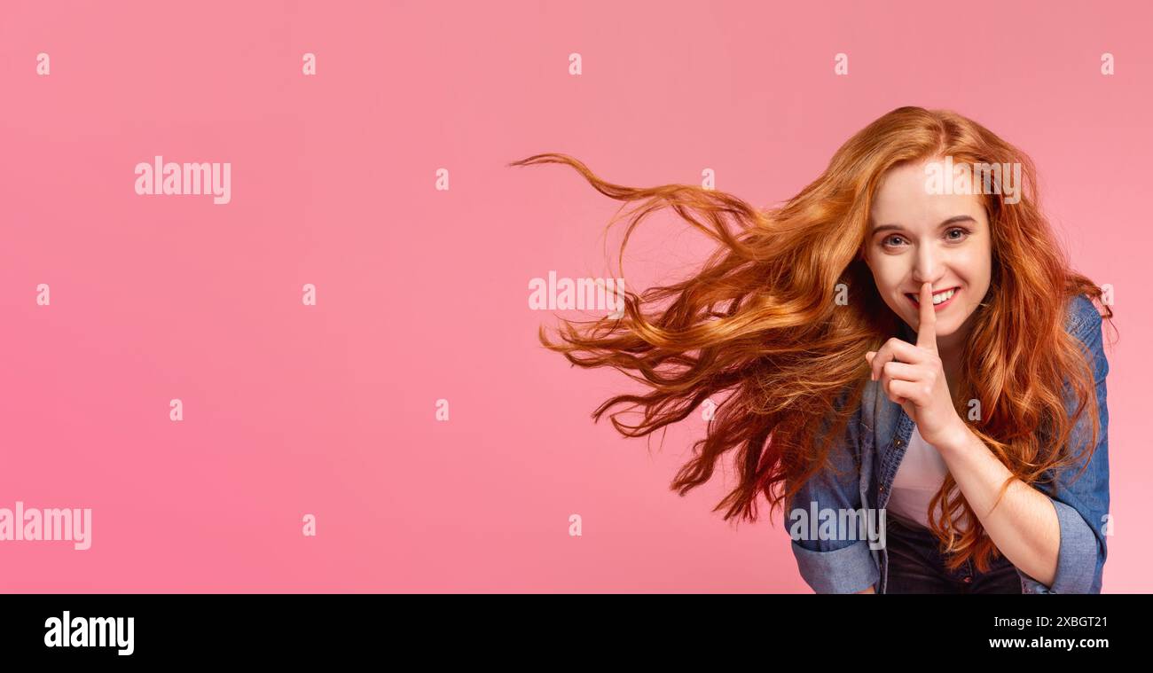 Giovane donna con fluente capelli rossi gesti per il silenzio Foto Stock