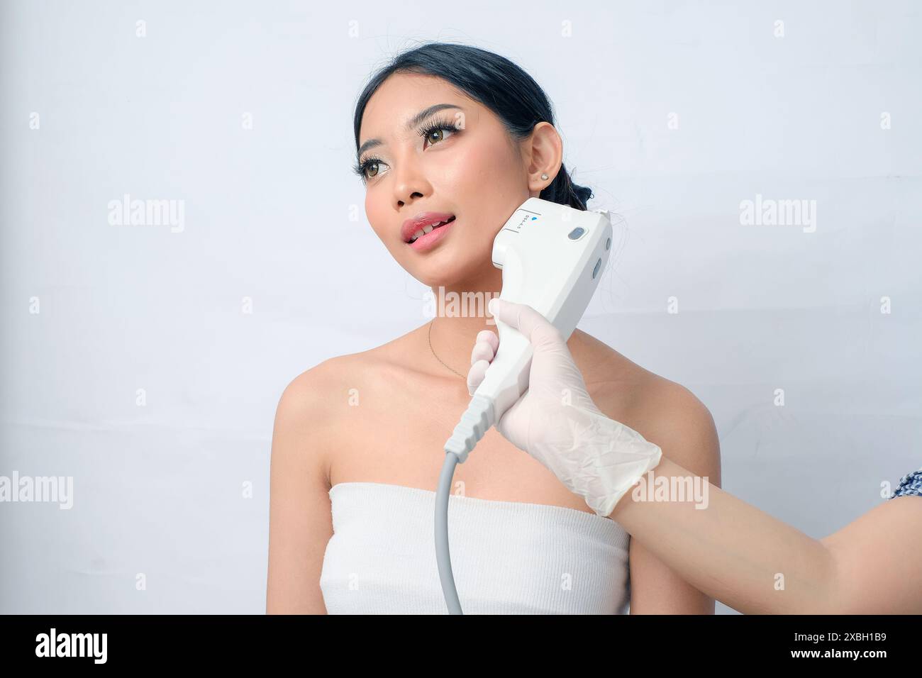 Trattamento laser a ultrasuoni focalizzati ad alta intensità (HIFU) su donne asiatiche con Updo Foto Stock