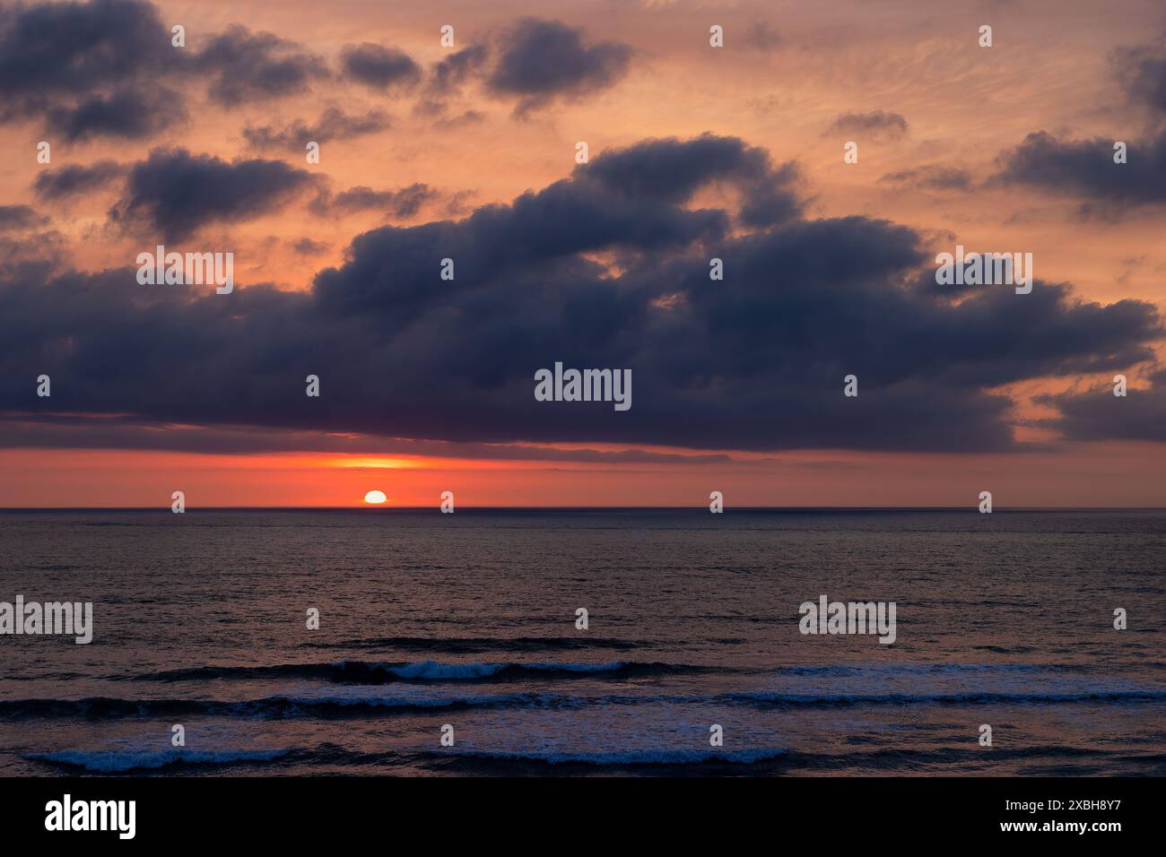 Il sole sorge nei cieli nuvolosi sull'Oceano Atlantico a Nags Head, a Outer Banks, North Carolina, Stati Uniti Foto Stock