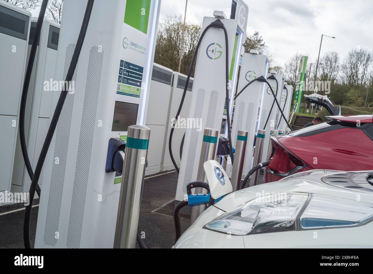 Veicoli elettrici in carica presso la stazione di servizio dell'autostrada Annandale sulla A74 (M) vicino a Lockerbie Scozia Foto Stock