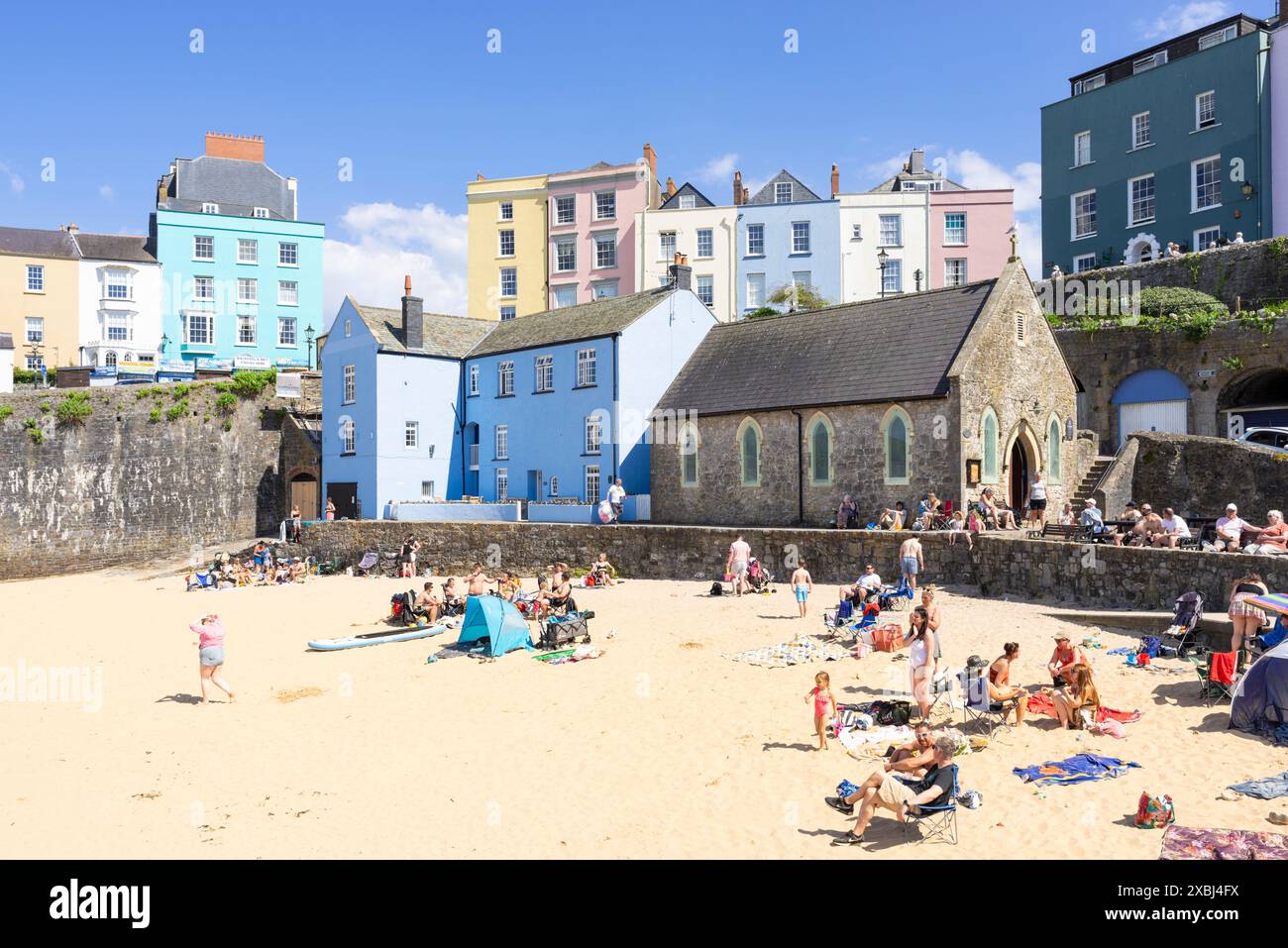 Tenby Harbour e Harbour Beach nel regno unito, con le case colorate Tenby e la chiesa di San Giuliano Tenby Carmarthan Bay Pembrokeshire West Wales UK Europa Foto Stock
