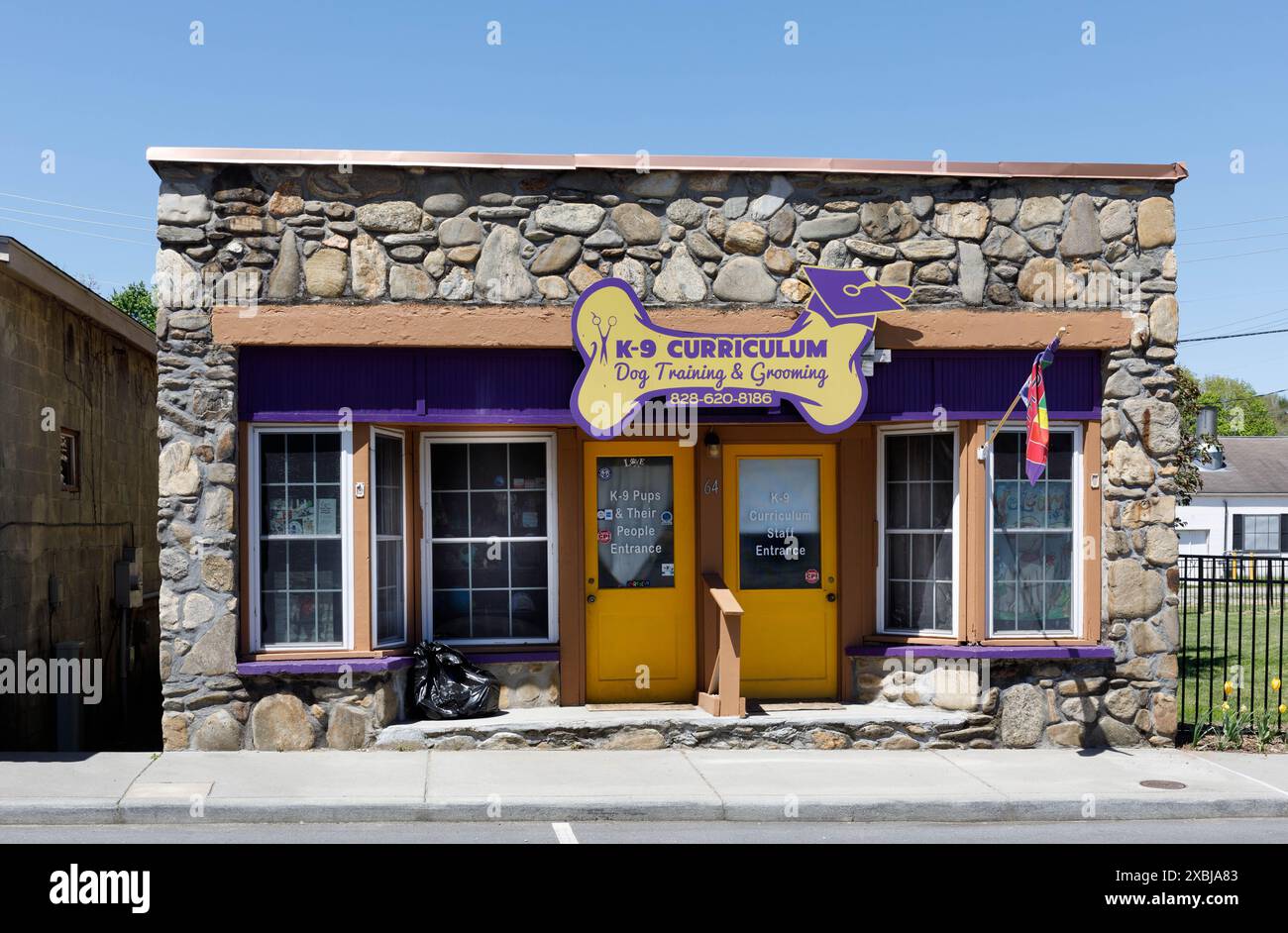 Clyde, North Carolina, Stati Uniti d'America - 4 maggio 2023: Un centro di formazione e cura del corpo dei cani chiamato 'K-9 Curriculum, in un piccolo edificio di roccia nel centro di Clyde. Foto Stock