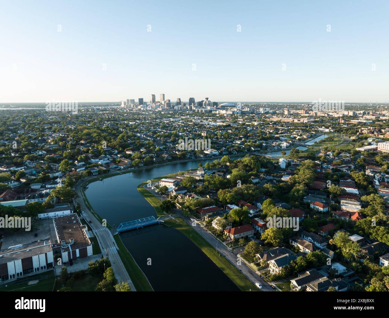 Vista aerea della storica Bayou St. John che si snoda attraverso un lussureggiante quartiere di New Orleans, con lo skyline della città visibile in lontananza. Foto Stock