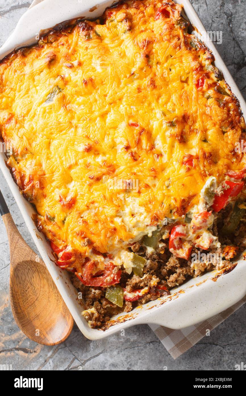 La John Wayne Casserole è una semplice casseruola di manzo macinata con base di biscotti e ricca di verdure e un ripiano di formaggio sul piatto da forno Foto Stock