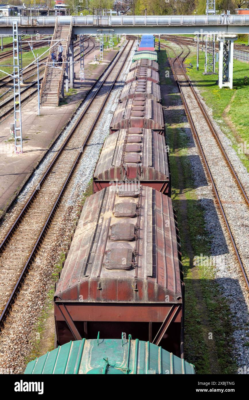 binari ferroviari con una fila di auto sui binari visti dall'alto Foto Stock