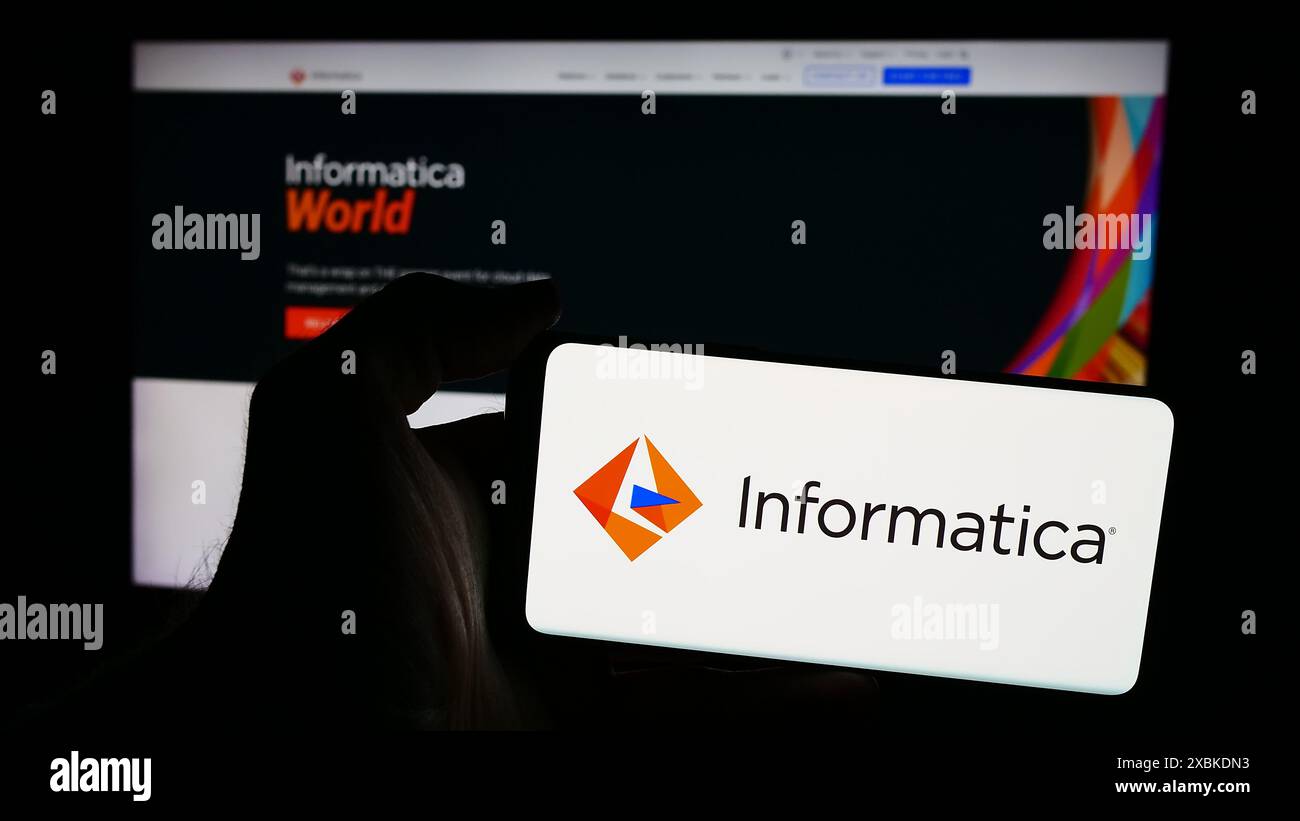 Persona che detiene un cellulare con il logo della società di sviluppo software statunitense Informatica Inc. Di fronte alla pagina Web aziendale. Mettere a fuoco il display del telefono. Foto Stock