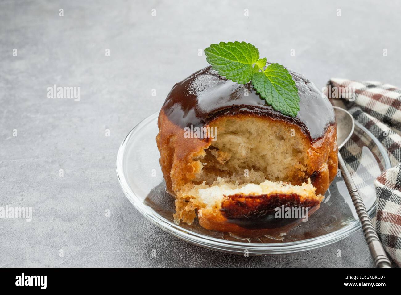 Rum baba decorato con cioccolato fondente su sfondo grigio Foto Stock