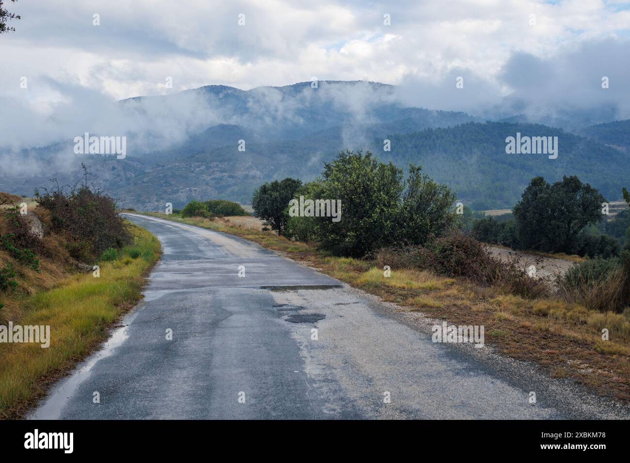 Paesaggio con pioggia e nuvole dalla strada di accesso rurale al parco naturale Fuente Roja di Alcoy, Spagna Foto Stock