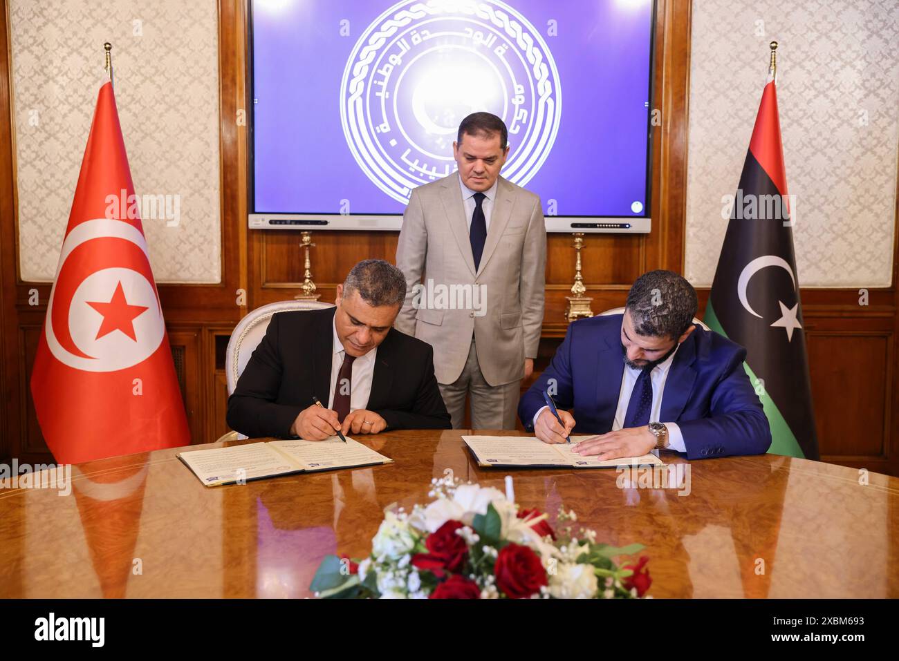 (240612) -- TRIPOLI, 12 giugno 2024 (Xinhua) -- il ministro dell'interno libico Emad al-Tarabelsi (R) e il ministro dell'interno tunisino Khaled Nouri (L) firmano un accordo di sicurezza a Tripoli, Libia, il 12 giugno 2024. Il valico di frontiera di Ras Ajdir, un collegamento terrestre vitale tra Libia e Tunisia, riaprirà parzialmente giovedì dopo mesi di chiusura, annunciato mercoledì dal Ministero dell'interno libico. (Ufficio informazioni del governo di unità nazionale libico via Xinhua) Foto Stock