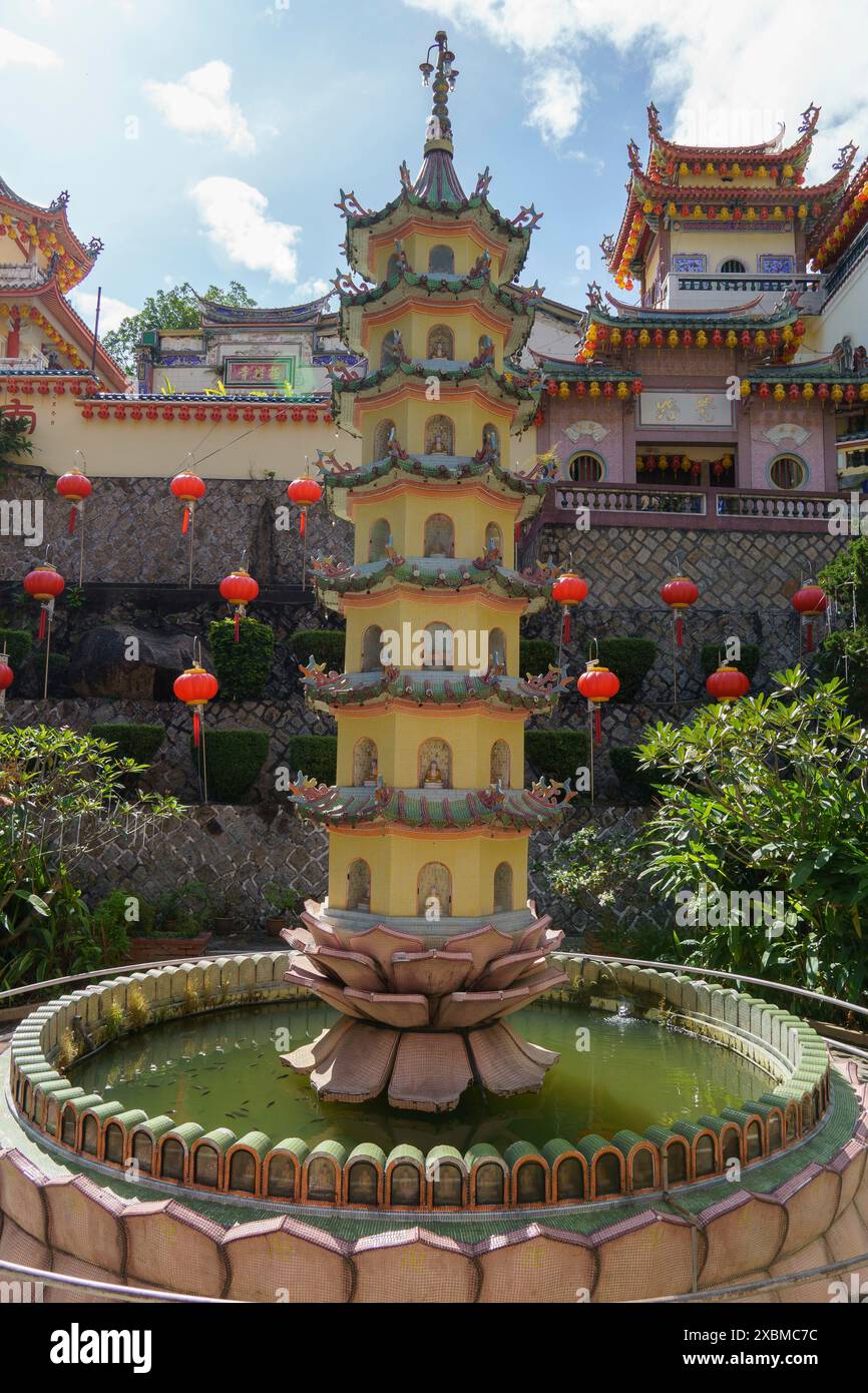 Una pagoda al centro di una fontana d'acqua in un complesso di templi con lanterne rosse, Pattaya, Thailandia Foto Stock