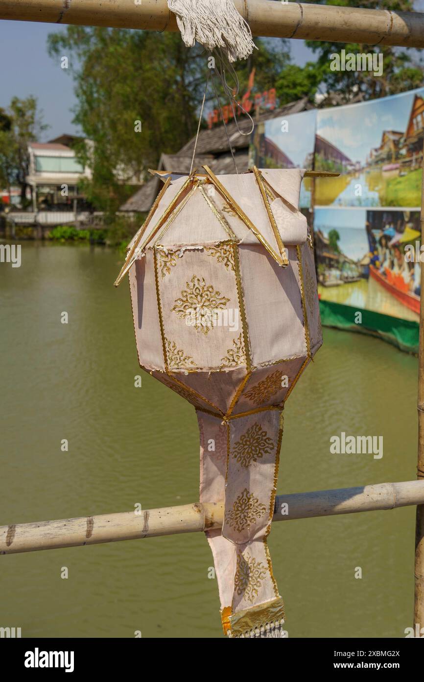 Tradizionale lanterna cinese con decorazioni dorate, appesa a un palo di bambù sull'acqua, Pattaya, Thailandia Foto Stock