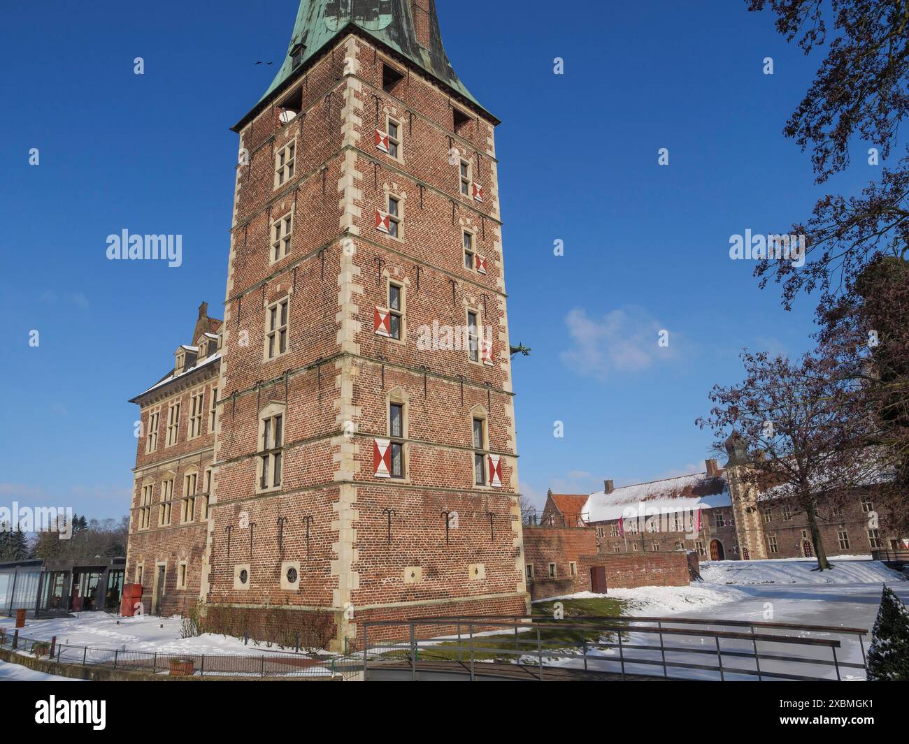 Grande castello in mattoni con torre, circondato da neve e cielo azzurro, tipica atmosfera invernale, Raesfeld, muensterland, germania Foto Stock