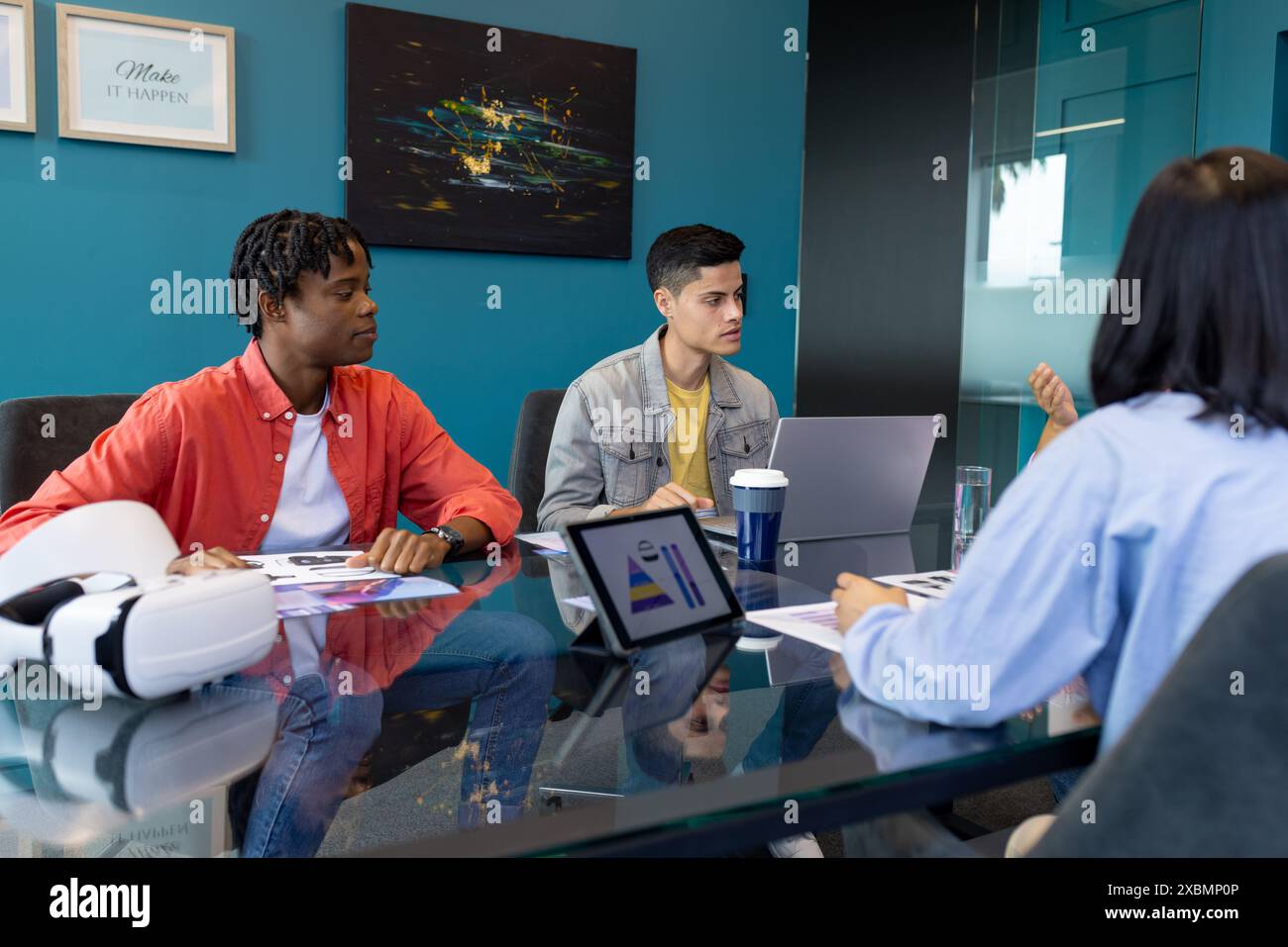Un giovane team collabora con notebook e tablet in diverse startup aziendali Foto Stock