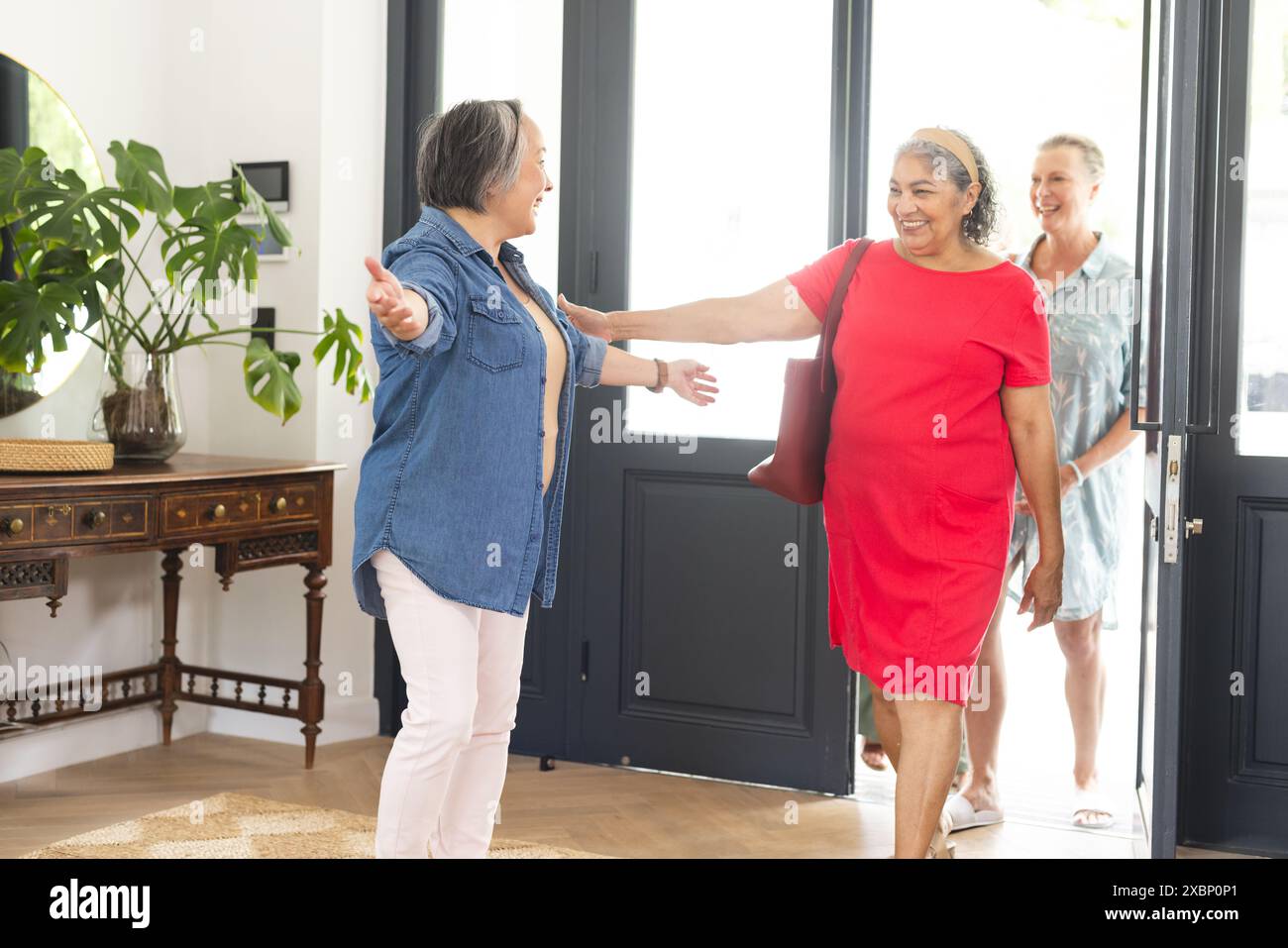 Gruppo eterogeneo di donne anziane che si salutano a braccia aperte e sorrisi Foto Stock