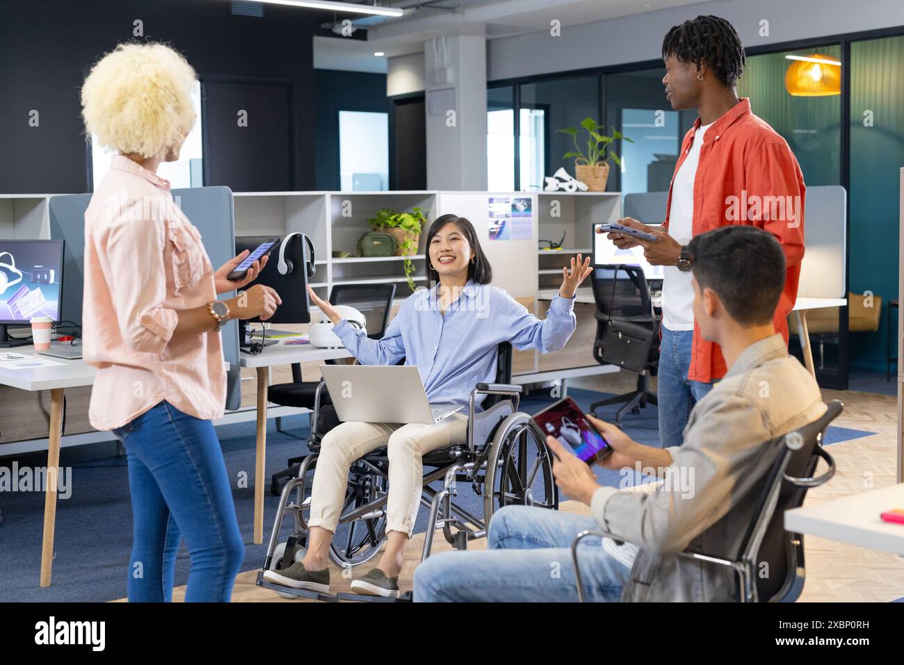 Diversi colleghi utilizzano smartphone e computer portatili in un ufficio moderno per le aziende Foto Stock
