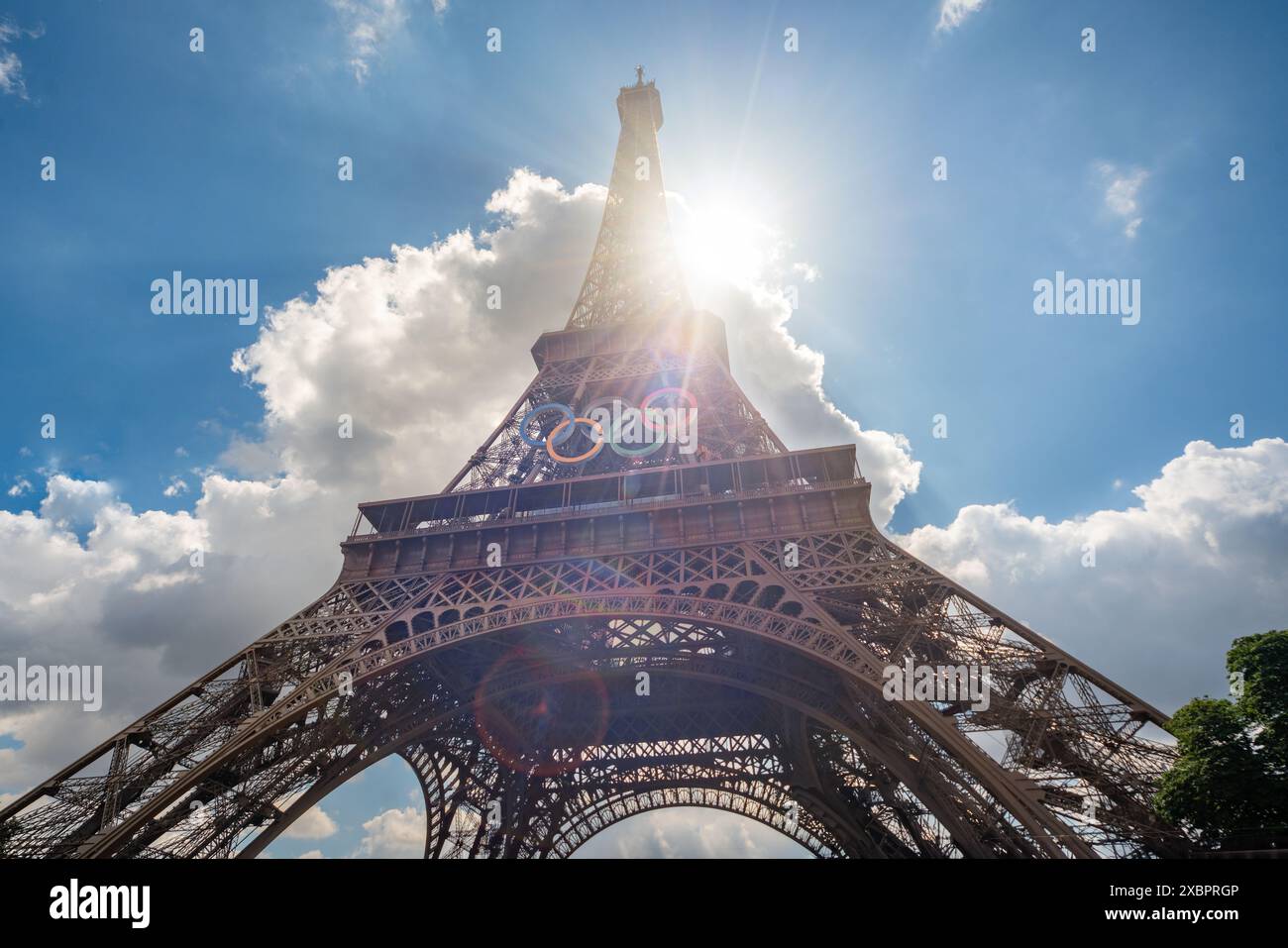 Vista grandangolare della Torre Eiffel con anelli per le Olimpiadi 2024 e i raggi del sole Foto Stock