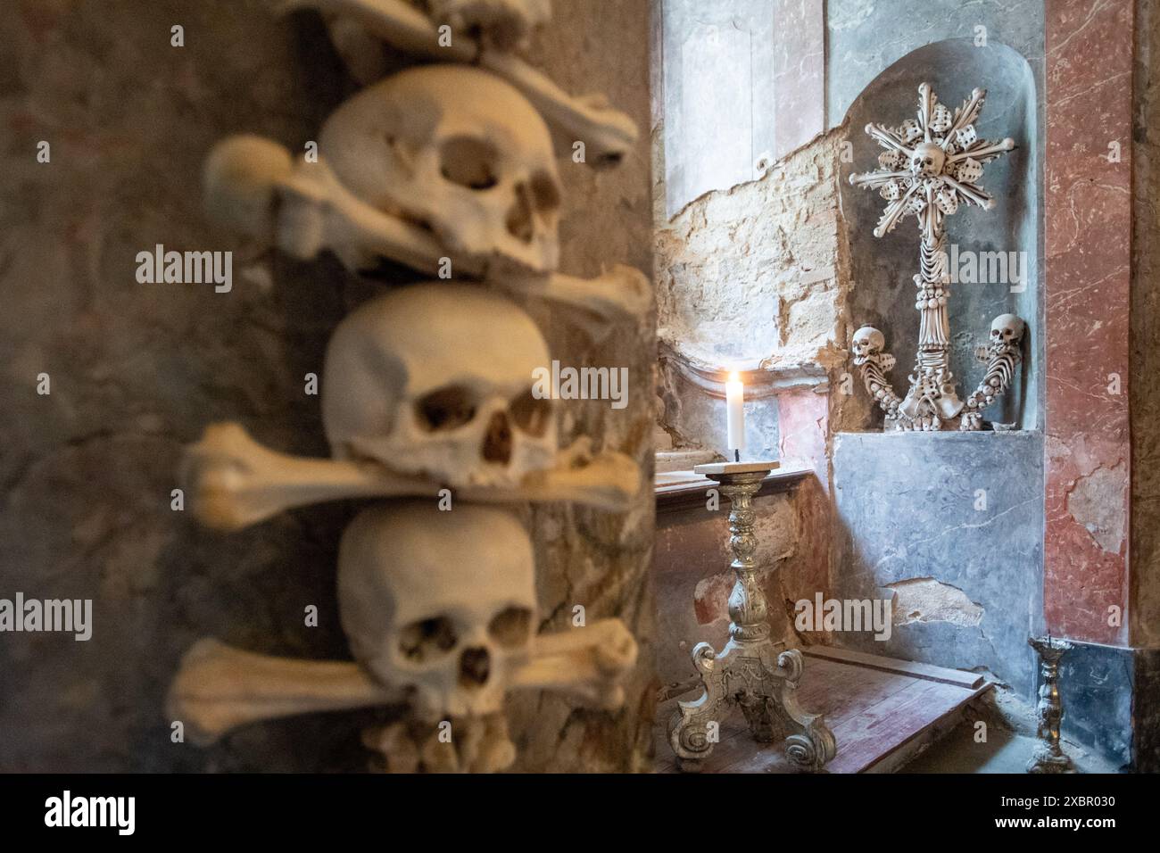 Cimitero di tutti i Santi con ossario a Kutna Hora, Repubblica Ceca, 13 giugno 2024. Gli esperti hanno completato il restauro della prima piramide di ossa umane, che ha dovuto essere smantellata durante la ricostruzione totale. Ci sono voluti due anni per rimontarlo. I singoli teschi e ossa, che venivano dalle vittime della peste e delle guerre ussite, dovevano essere puliti, trattati, asciugati e riassemblati dopo che la struttura in legno era stata installata. Ci sono quattro piramidi di ossa nell'ex cappella del cimitero del XIV secolo, la prima nella parte nord-occidentale è stata riparata. Gli altri tre sono in attesa Foto Stock