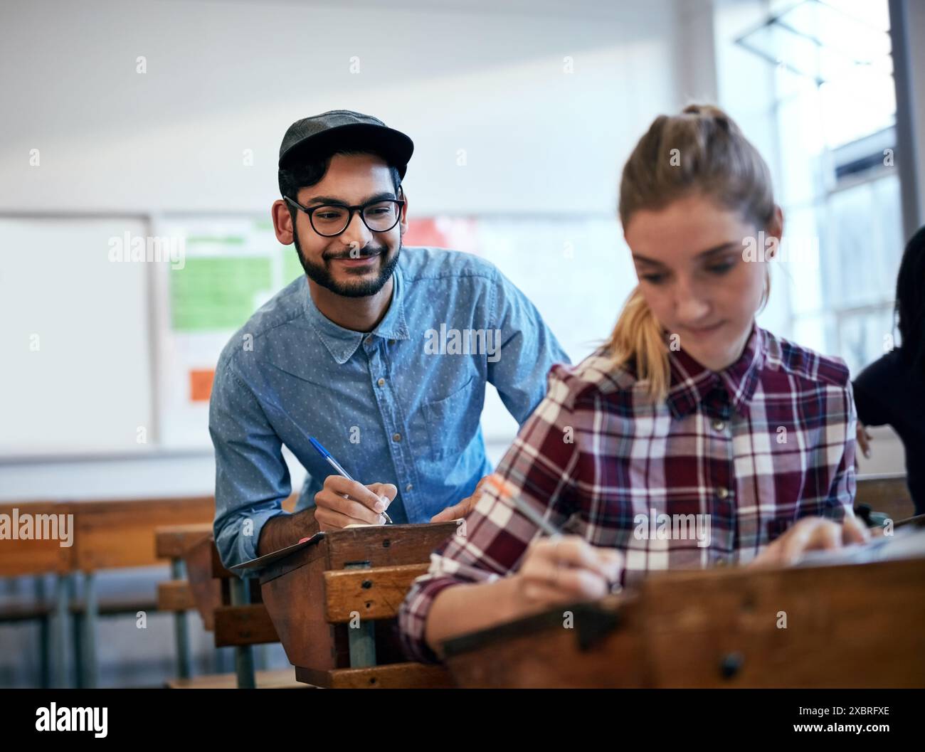 Studenti, che imparano e imbrogliano per l'università come gruppo al college o a scuola in classe per compiti. Persona maschile, persone e test accademico per Foto Stock