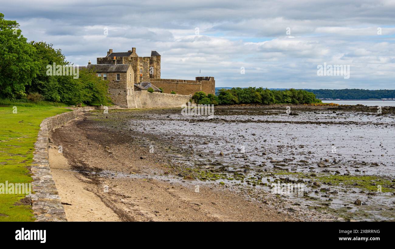 L'aspro Castello di Blackness si erge sullo sfondo costiero spettacolare del Firth of Forth, a guardia degli approcci costieri. Foto Stock