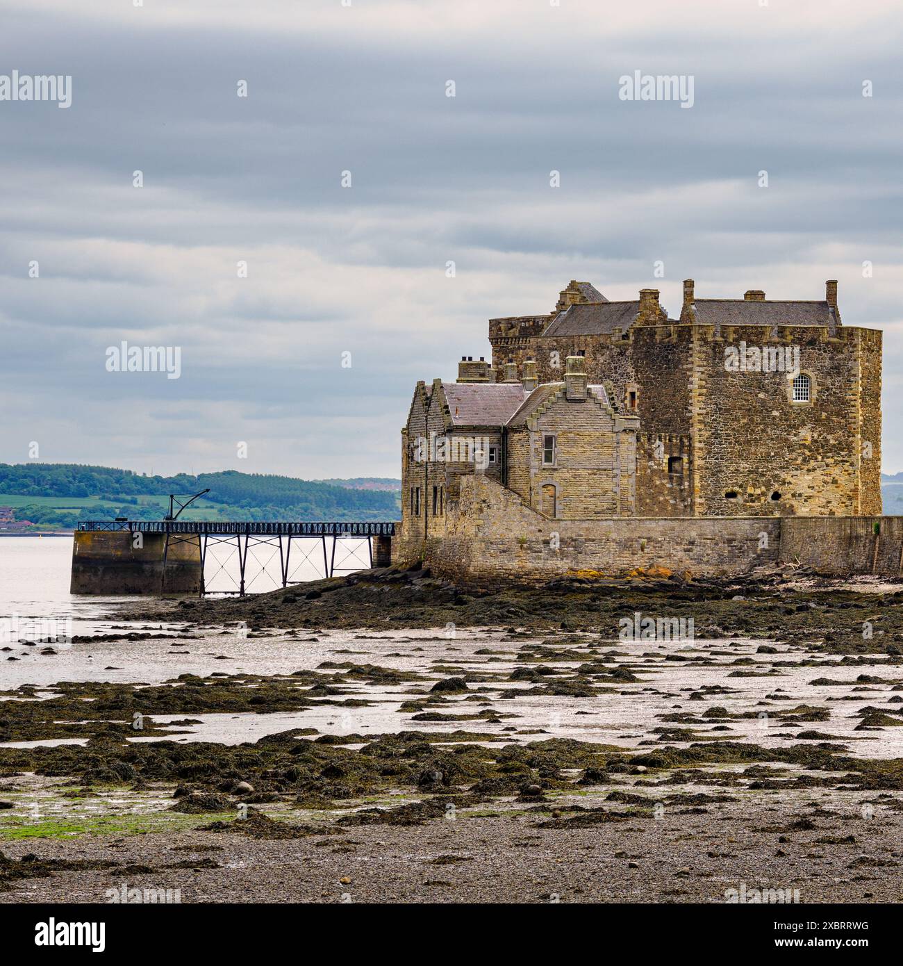 L'aspro Castello di Blackness si erge sullo sfondo costiero spettacolare del Firth of Forth, a guardia degli approcci costieri. Foto Stock