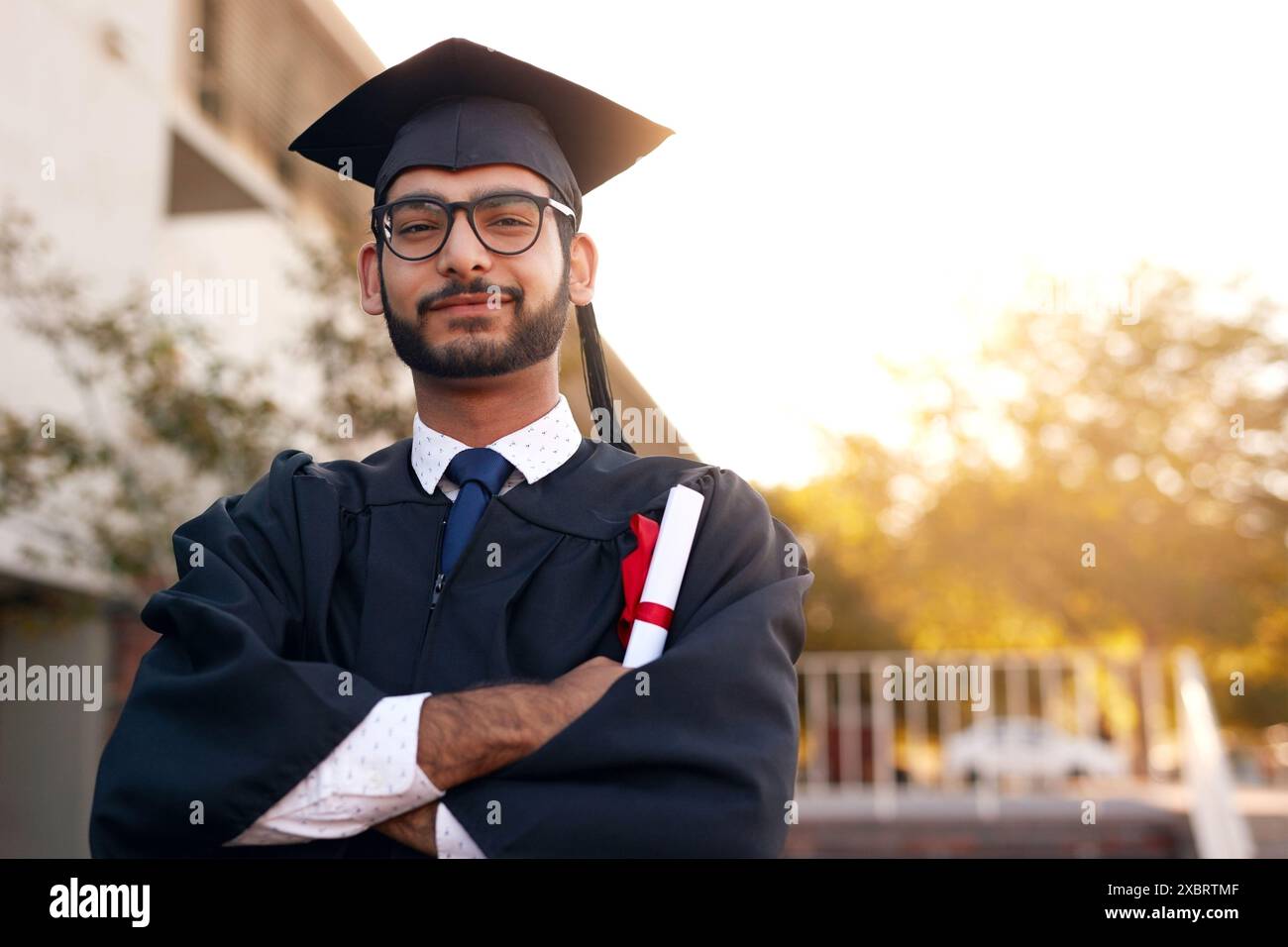 Sorridi, college e ritratto dell'uomo nel campus per l'istruzione, la laurea e il successo accademico. Felice, premiare e studiare con lo studente per l'università Foto Stock