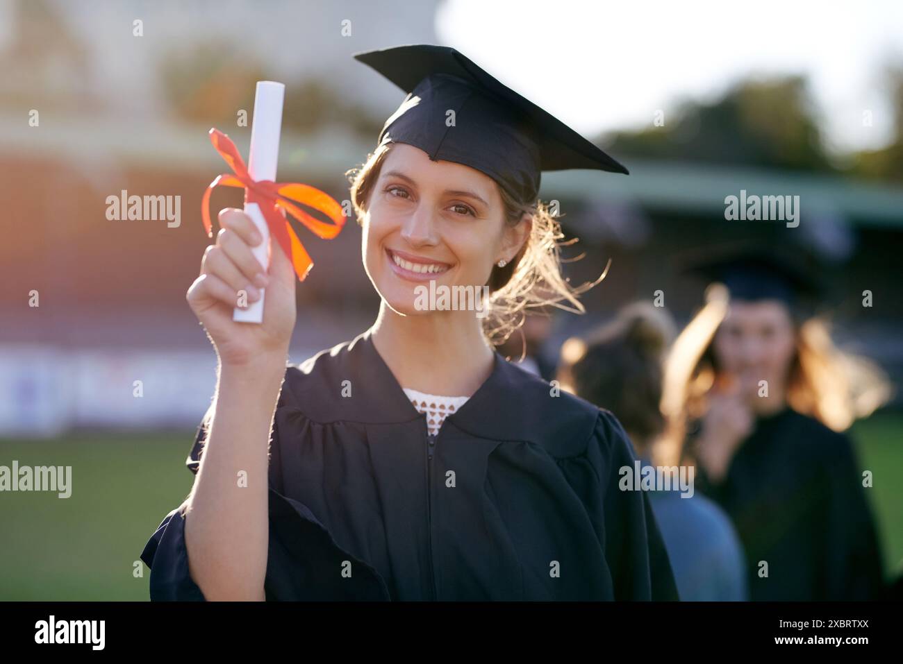 Sorridi, università e ritratto della donna nel campus per l'istruzione, il college e il successo accademico. Felice, premiato o studia con uno studente per la laurea Foto Stock