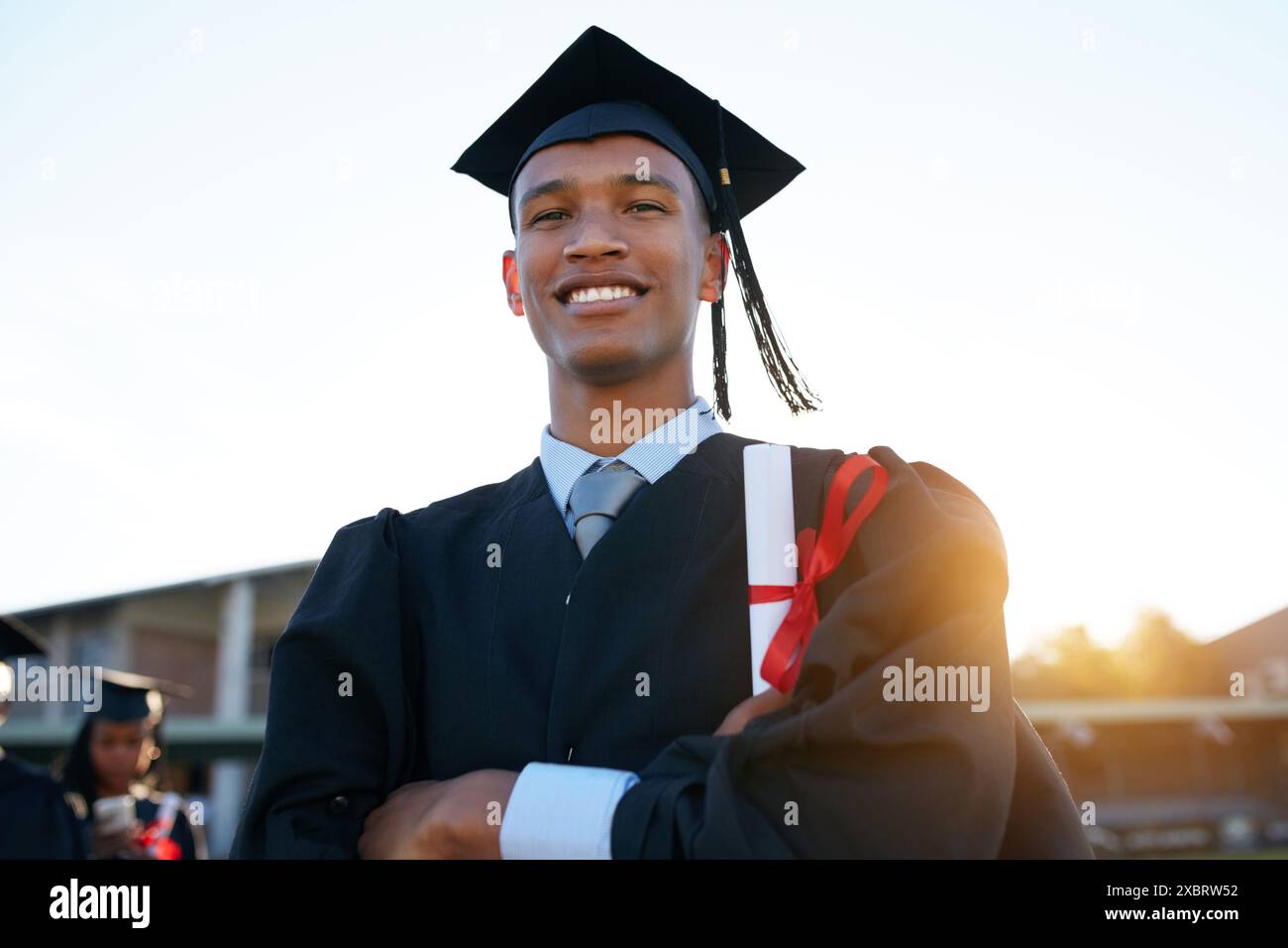 Sorridi, laurea e ritratto di un uomo nero nel campus per l'istruzione, il college o il successo accademico. Felice, premiare o studiare con uno studente per l'università Foto Stock