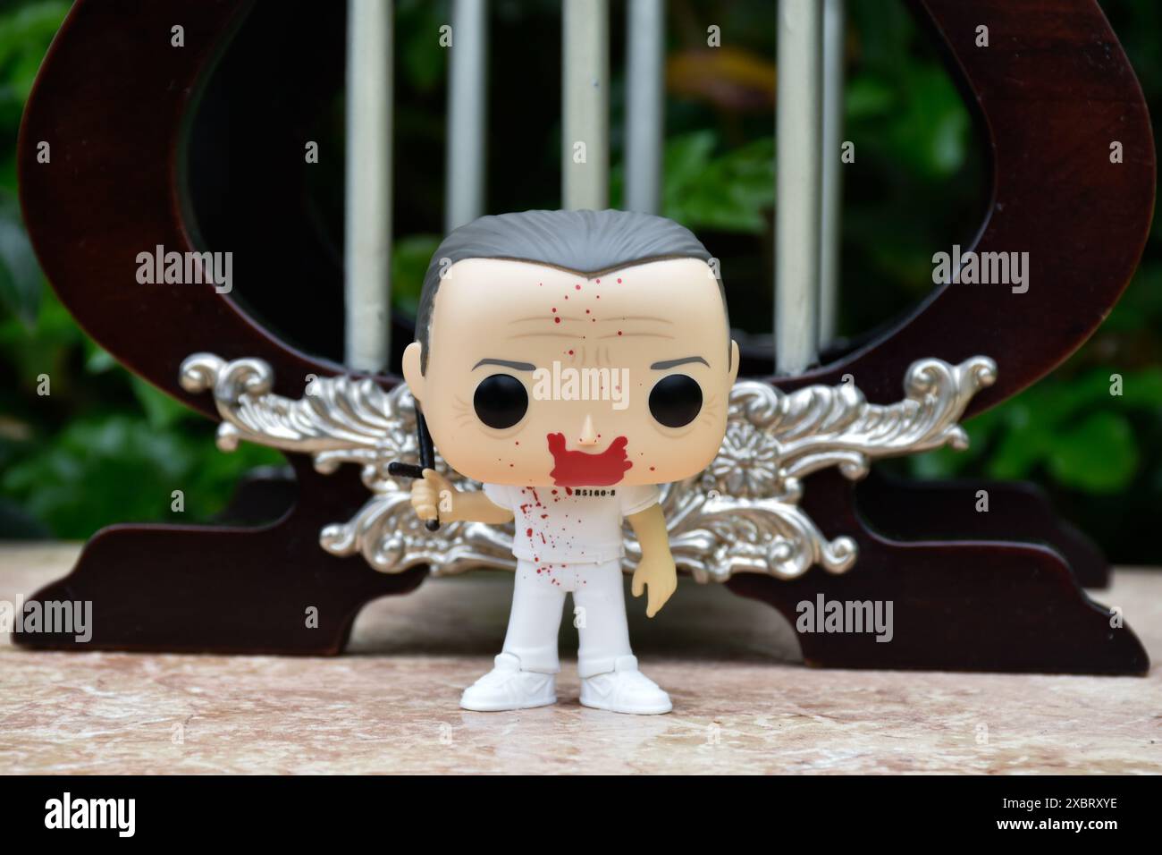 Funko Pop action figure di Hannibal Lecter dal popolare film horror Silence of the Lambs. Giocattolo in piedi contro le barre della prigione in miniatura d'epoca. Foto Stock