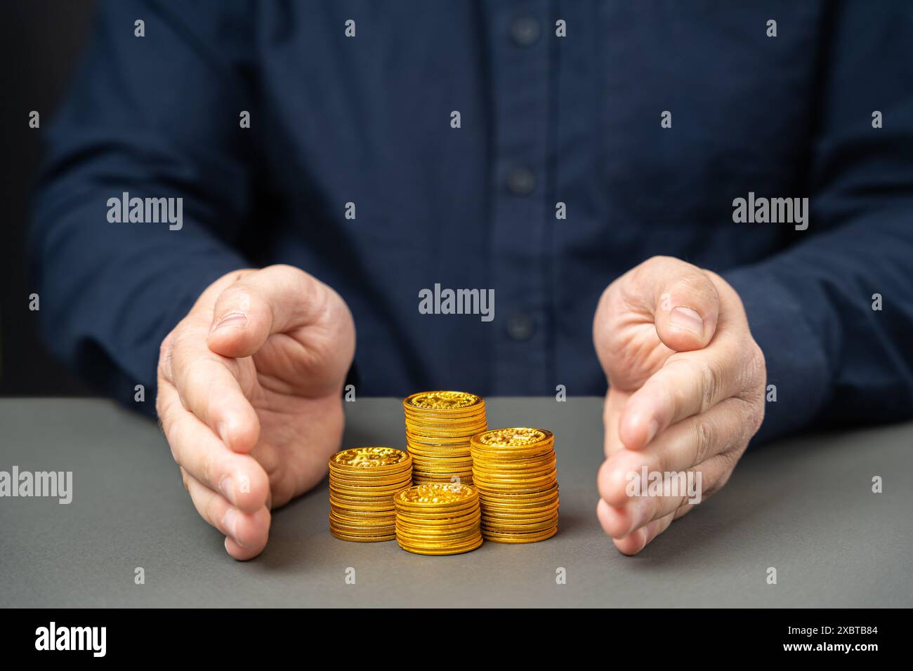 Uomo d'affari che copre una pila di monete. Concetto di assicurazione contro il rischio finanziario. Investimenti, depositi e prestiti. Rischi e transazioni monetarie. Assicurazione con Foto Stock