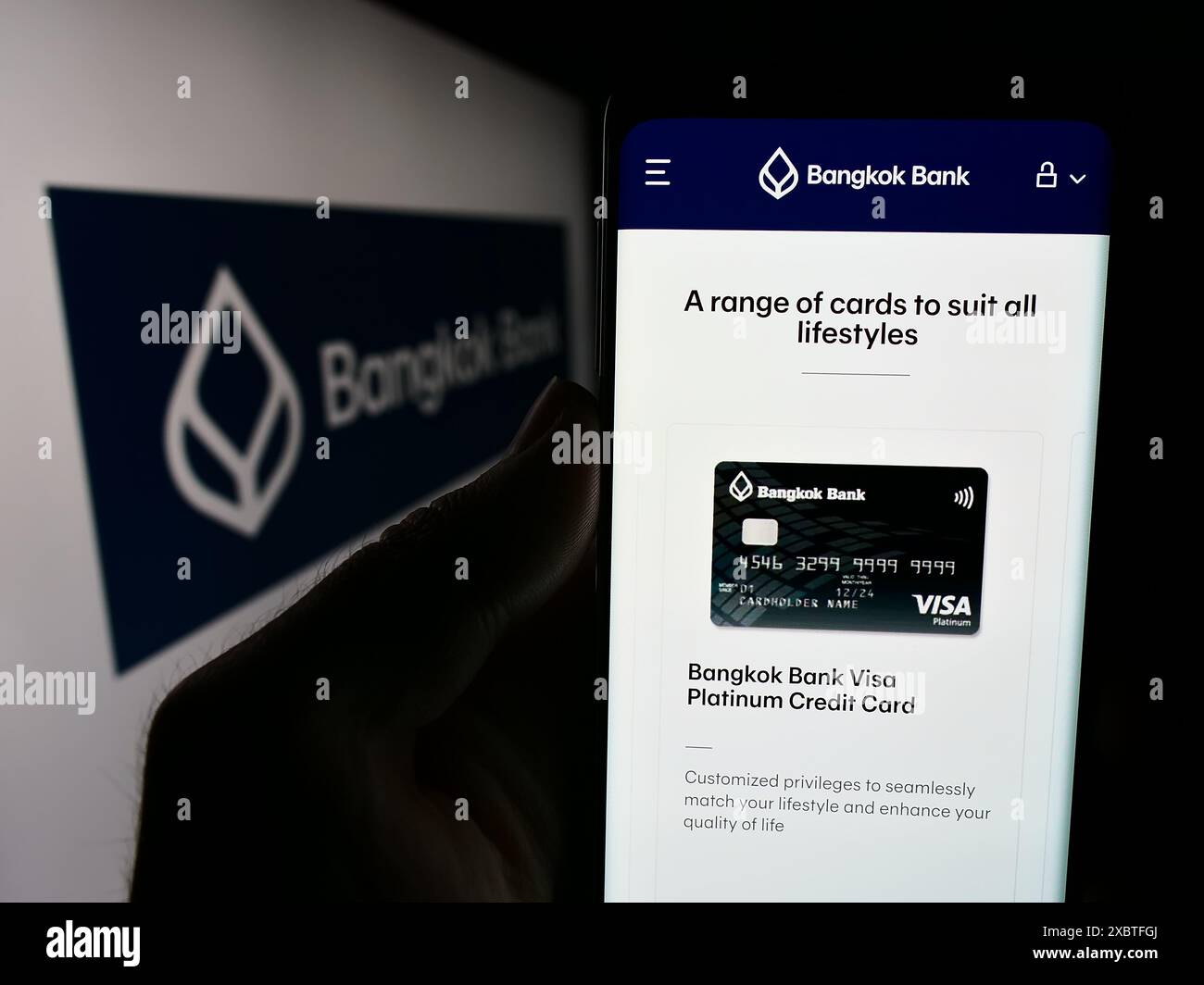 Persona che detiene un cellulare con pagina web della Thai Bangkok Bank Public Company Limited davanti al logo aziendale. Messa a fuoco al centro del display del telefono. Foto Stock