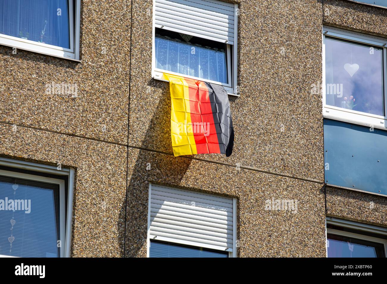 Bandiera tedesca su una finestra a strapiombo in vista dell'imminente Campionato europeo di calcio in Germania Foto Stock