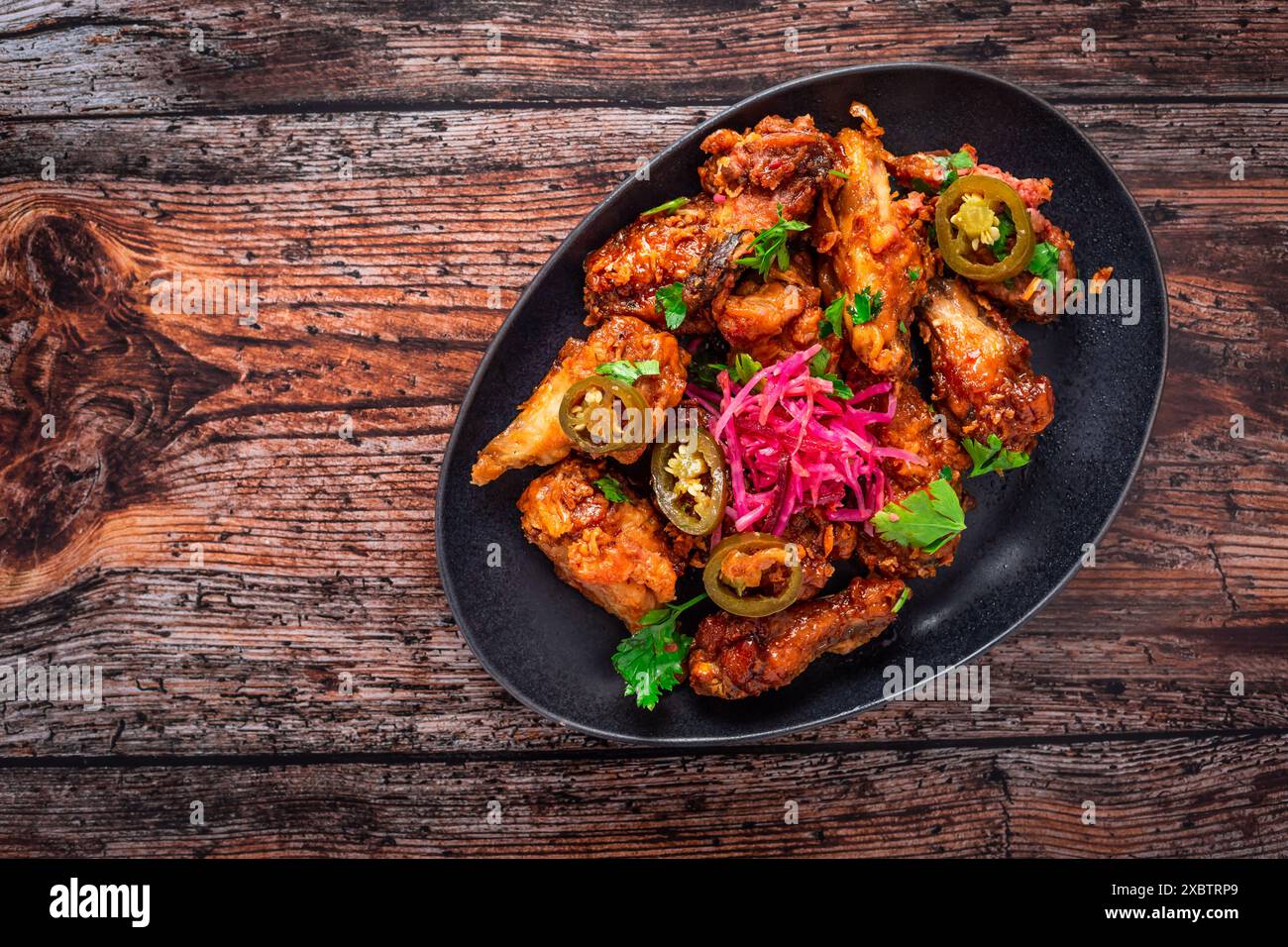 Ali di pollo al limone e all'aglio con verdure sottaceto e jalapenos. Cucina asiatica. Foto Stock